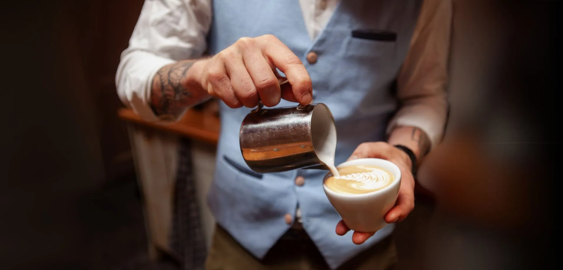 Barista schenkt melk in een cappuccino
